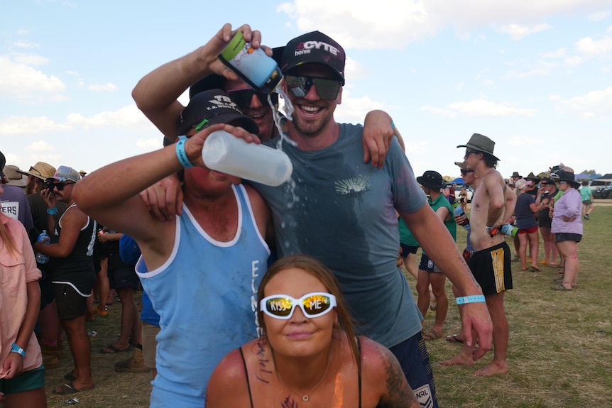 photo shows boys pouring beer on a girl that has 'kiss me' on her sunglasses