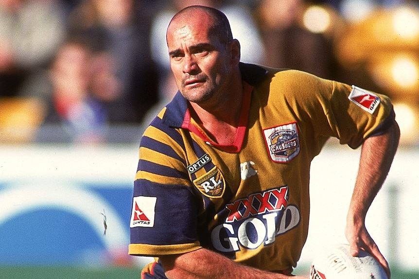 A man looks to pass the ball during a rugby league match