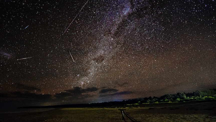 Meteors streak across night sky