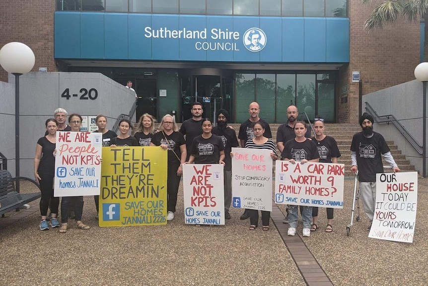 A group of people stand outside Sutherland Shire Council building with signs
