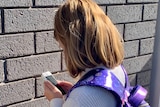A close up photo of an unidentified girl using a mobile phone
