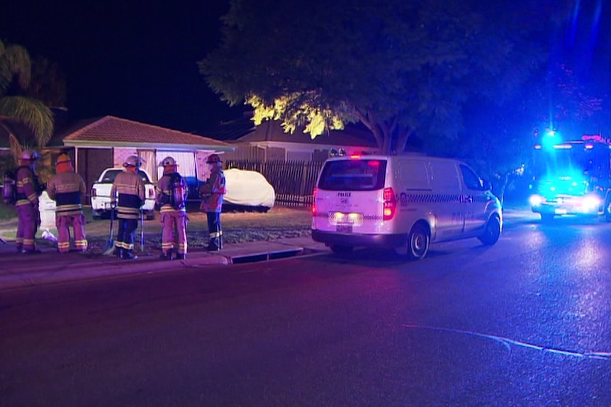 Police and firefighters at night outside a house