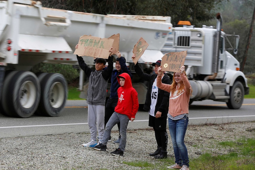 Residents hold up signs thanking truck drivers near Oroville Dam