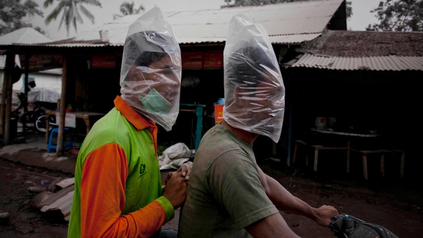 Motorcyclists wear plastic bags to protect their faces from ash.