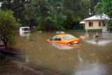 Vehicles disappear under the floodwaters at Edmonstone St in the Brisbane suburb of Newmarket.