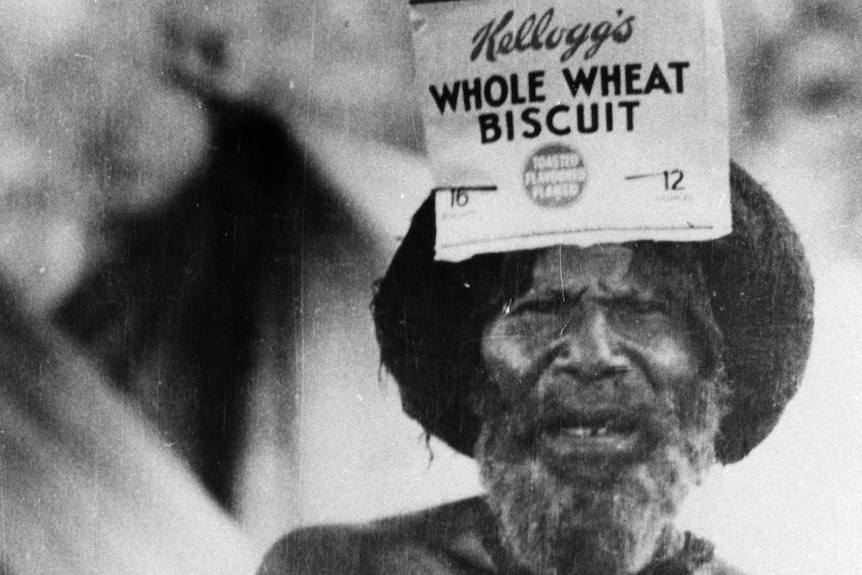 A PNG man wears a Kellogg's box as a headdress.