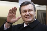 Ukrainian presidential candidate Viktor Yanukovich waves to the media after voting