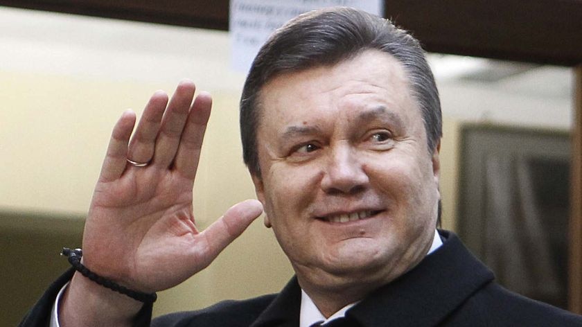 Ukrainian presidential candidate Viktor Yanukovich waves to the media after voting