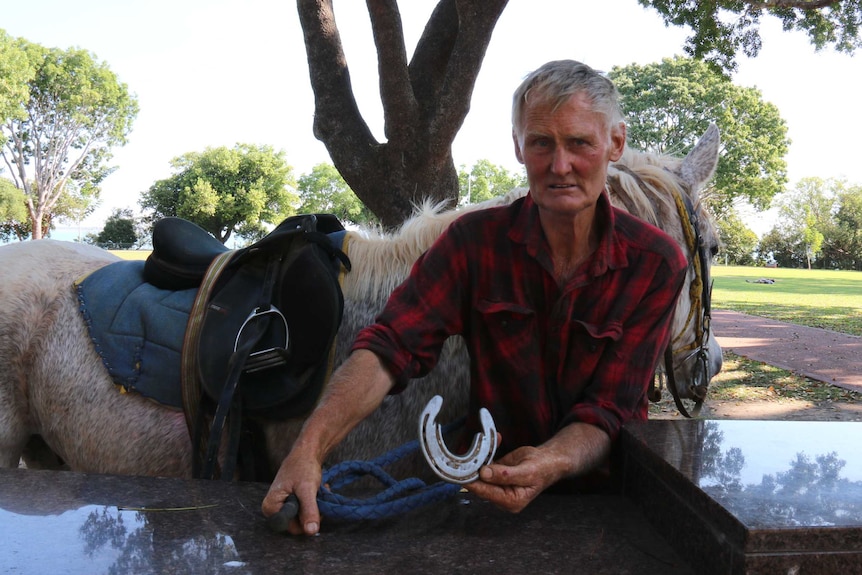Richie Foster holds a horse shoe after riding from Apsley in Victoria to Darwin in the NT