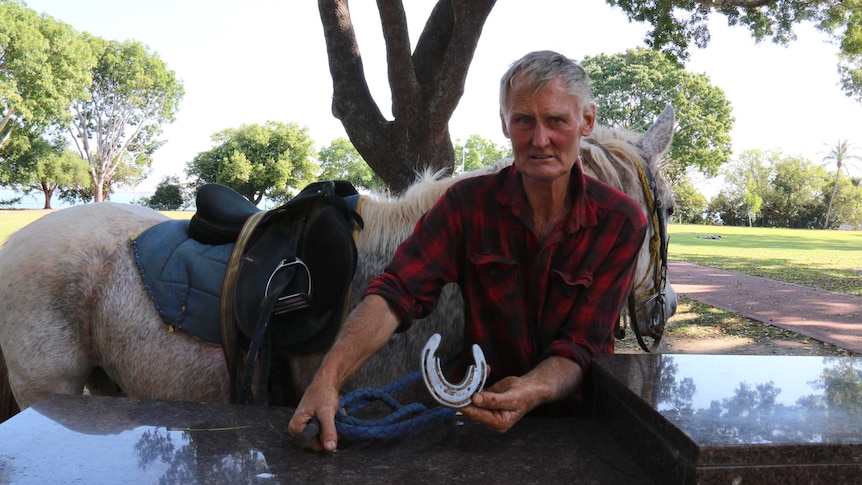 Richie Foster holds a horse shoe after riding from Apsley in Victoria to Darwin in the NT