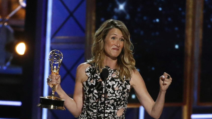 Laura Dern looks overjoyed as the stands on stage with her emmy award.