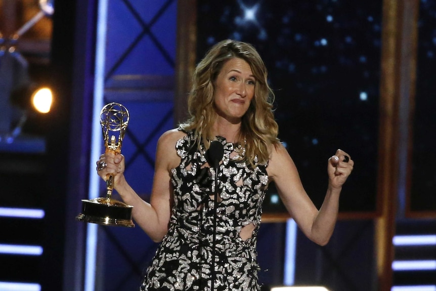 Laura Dern looks overjoyed as the stands on stage with her emmy award.