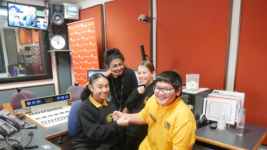 Boulder Primary School students Lillian, Georgia and Jack with reporter Dinushi Dias in the radio studio in Kalgoorlie