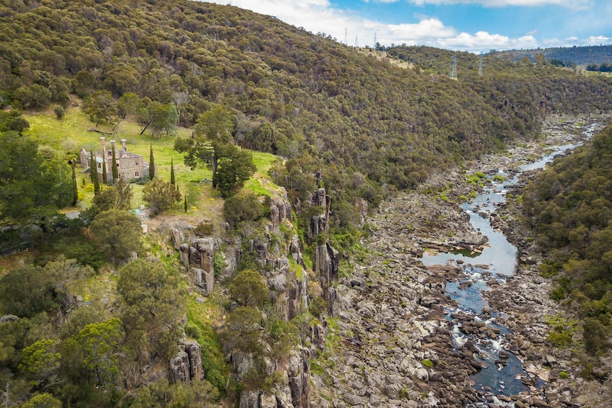 An aerial shot of a historic stone building on top of a cliff next to the Launceston Cataract Gorge