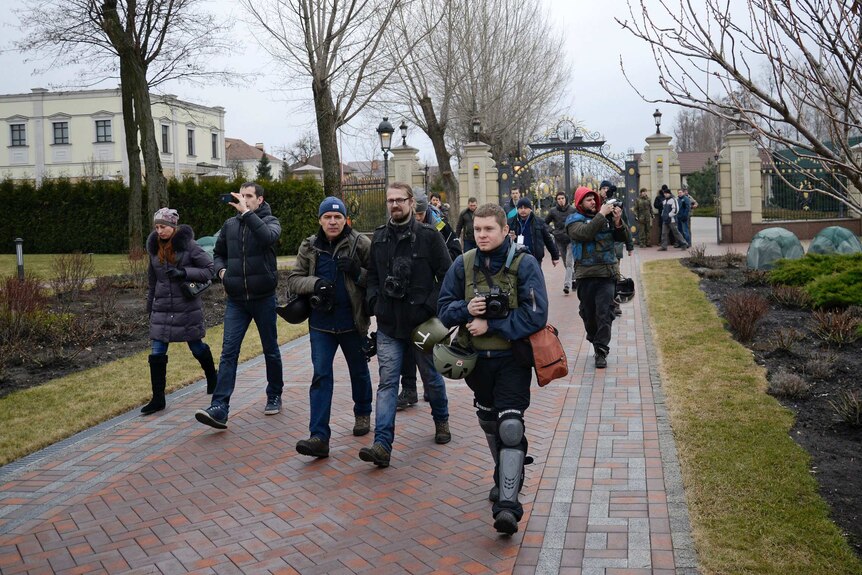 Anti-government protesters and journalists walk into the private residence of Ukraine president Viktor Yanukovich