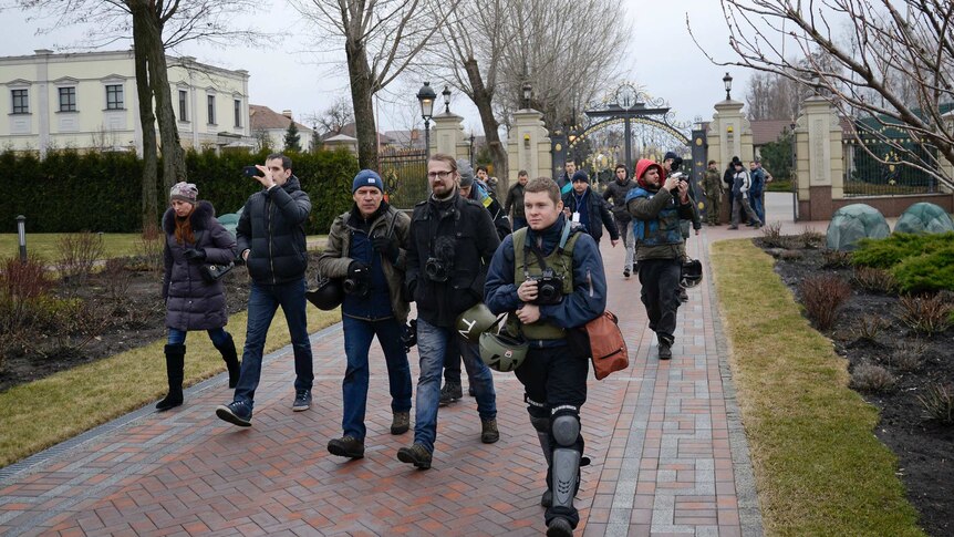 Anti-government protesters and journalists walk into the private residence of Ukraine president Viktor Yanukovich