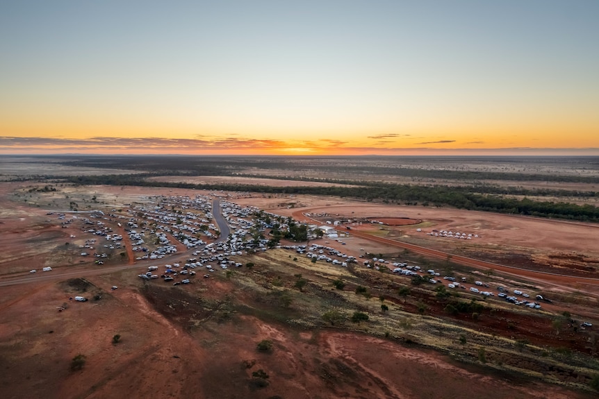 An aerial view of an outback town surrounded by red dirt land