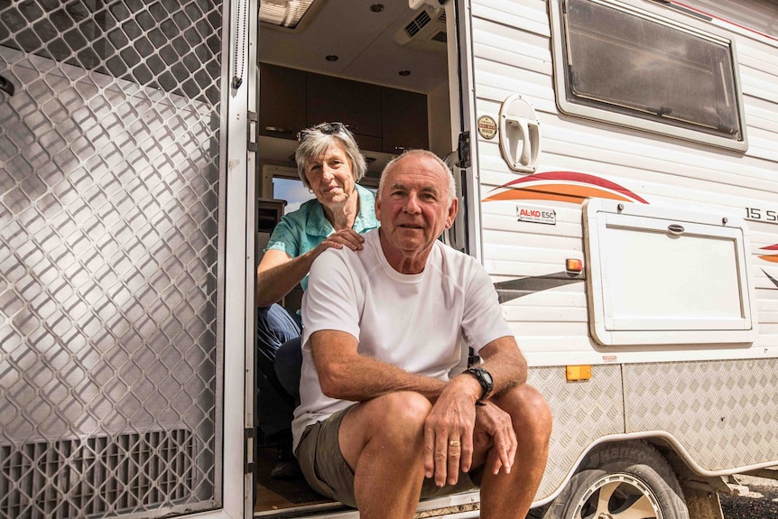 Man and woman standing in caravan.