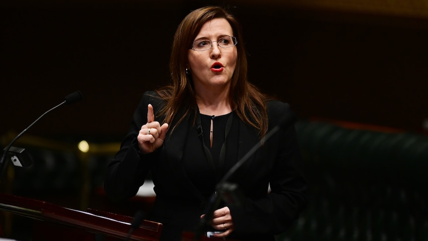 A woman wearing glasses pointing