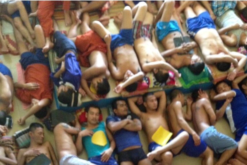 Rows of men sleeping in cramped conditions side-by-side