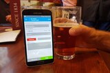 A customer pays for a glass of beer using bitcoin