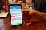 A customer pays for a glass of beer using bitcoin