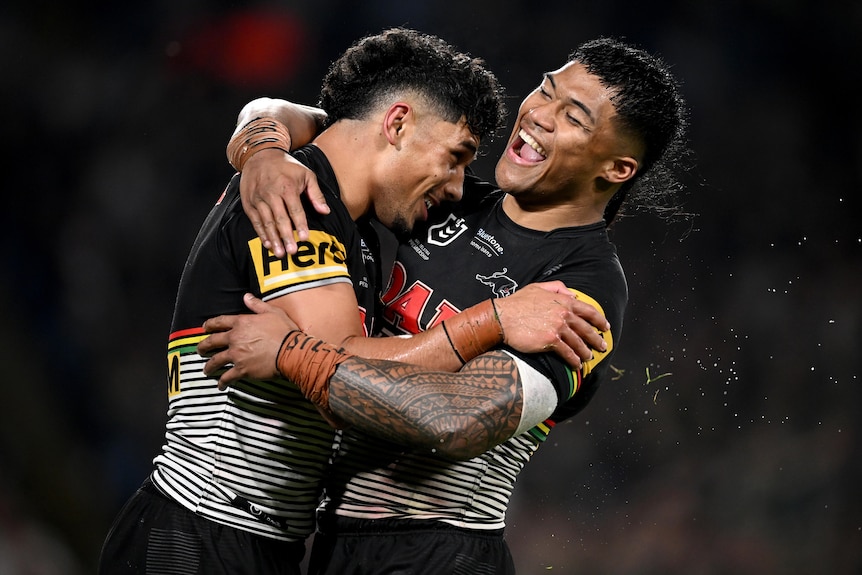 Two Penrith Panthers NRL players embrace as they celebrate a try.