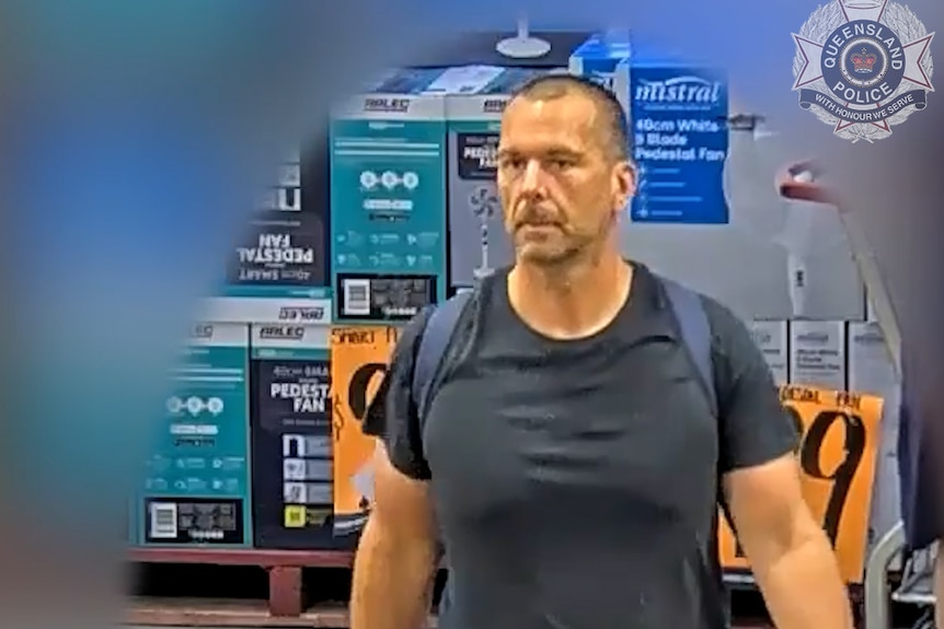 tall man walking through shop with backpack