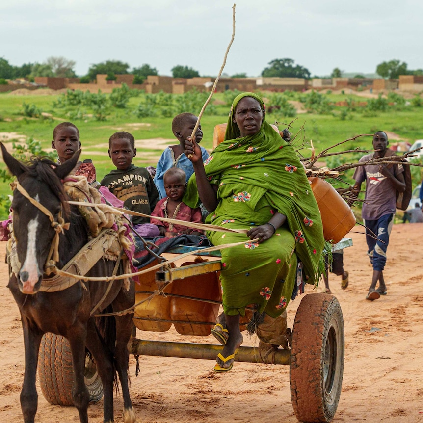 A mother and her three children sit on a cart pulled by a horse.