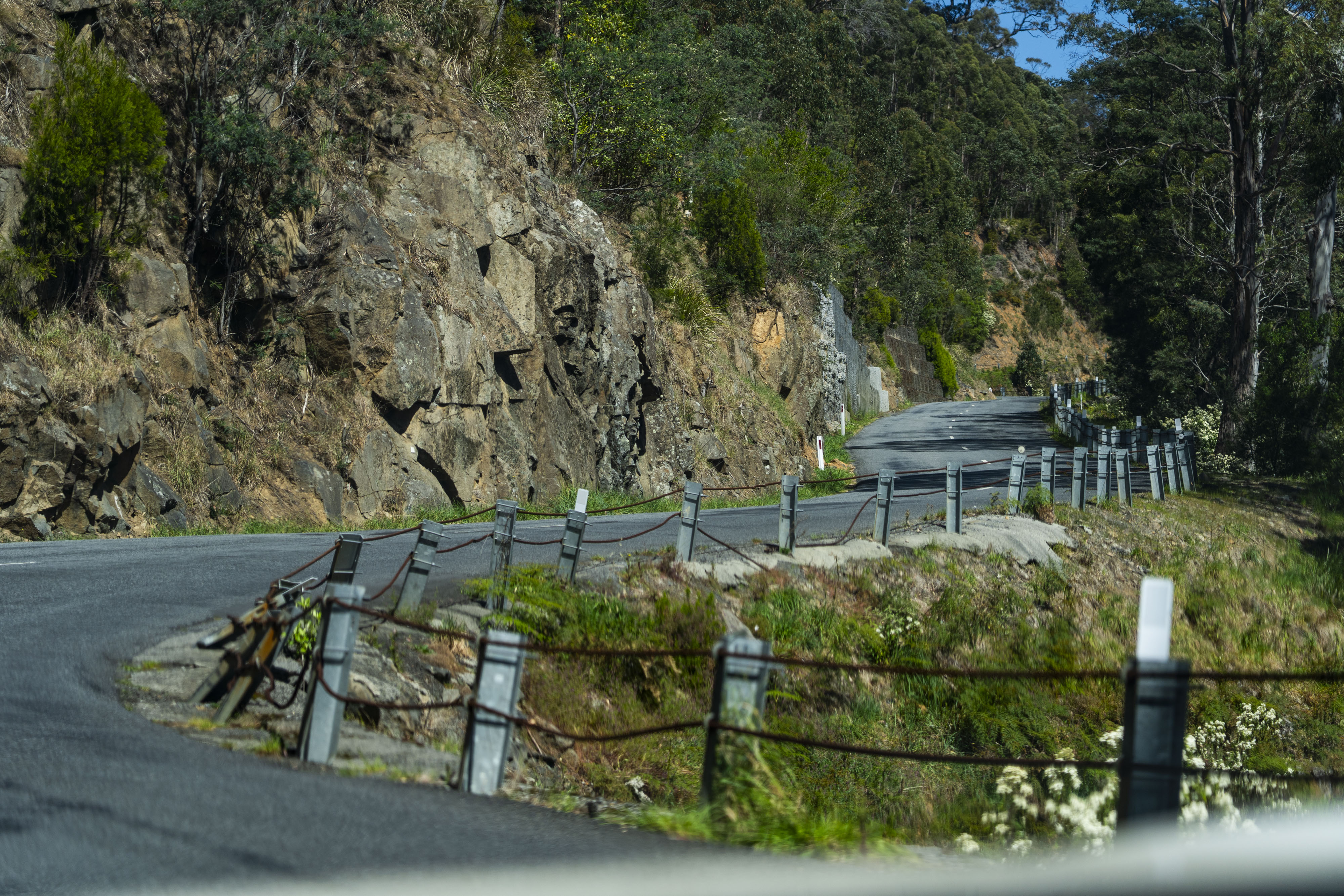 a twisty windy road surrounded by high grey walls of rock