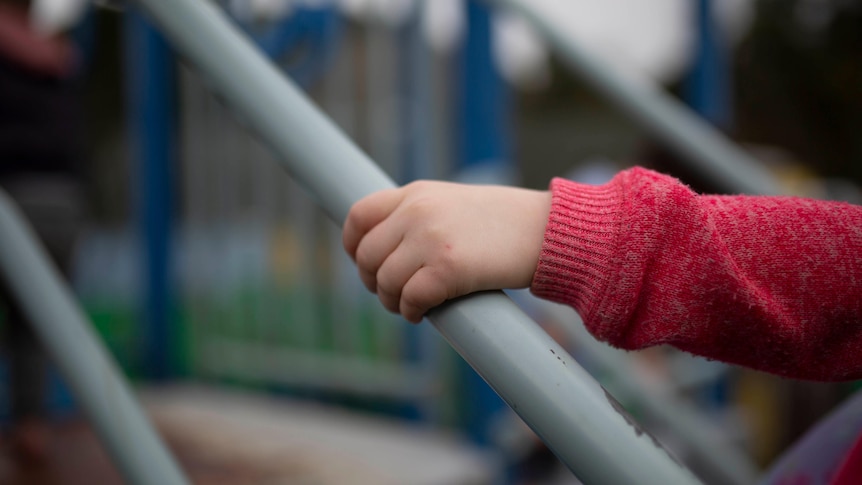 Child's hand on play equipment