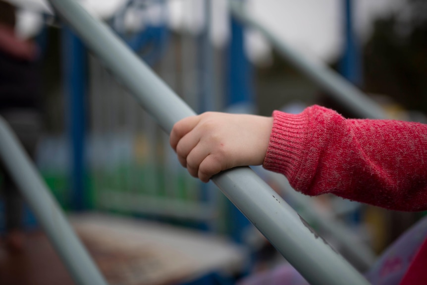 Child's hand on play equipment