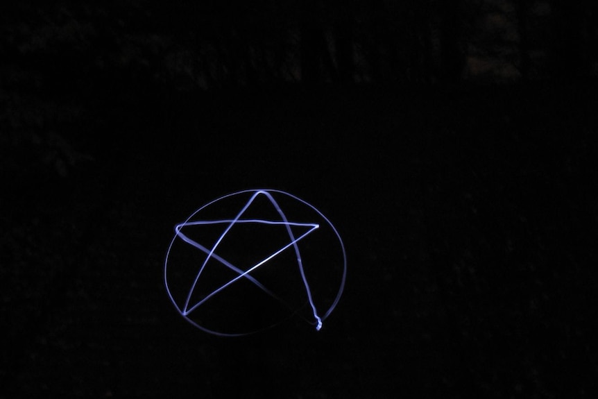 A pentagram drawn in blue light on a black background