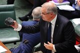 Scott Morrison holds out a lump of coal.