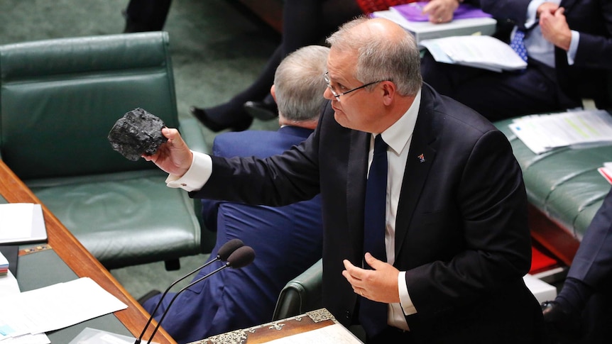Scott Morrison holds out a lump of coal.