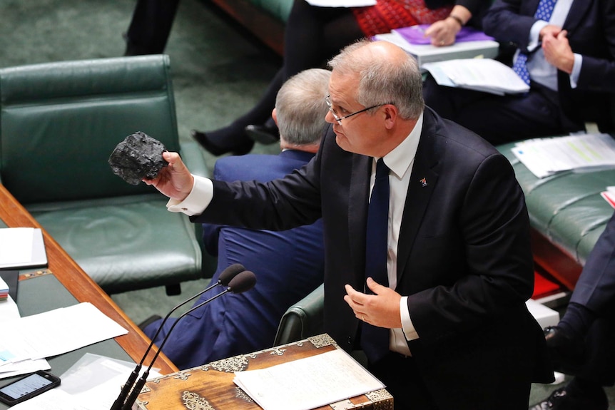 Scott Morrison holds out a lump of coal in the House of Representatives. 