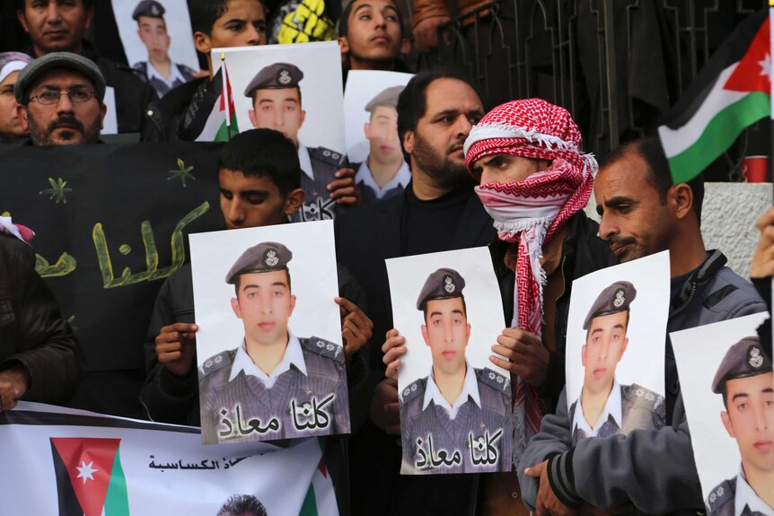 Jordanian activists hold photos of captured pilot
