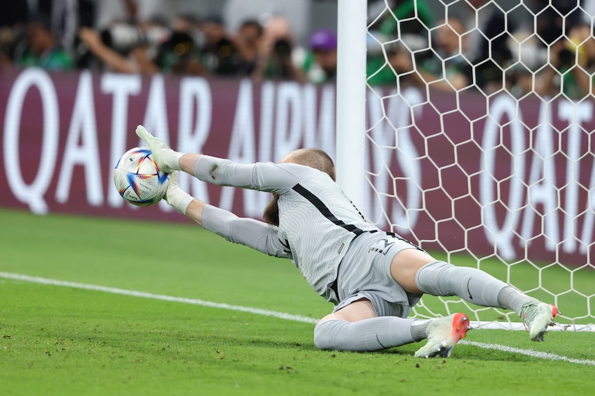 Andrew Redmayne saves a penalty by stretching out to the left 