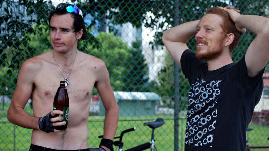 Bike polo spectators drink beers on the sideline