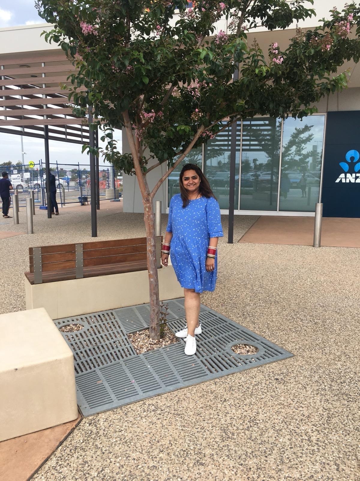 a woman standing in front of a shopping centre