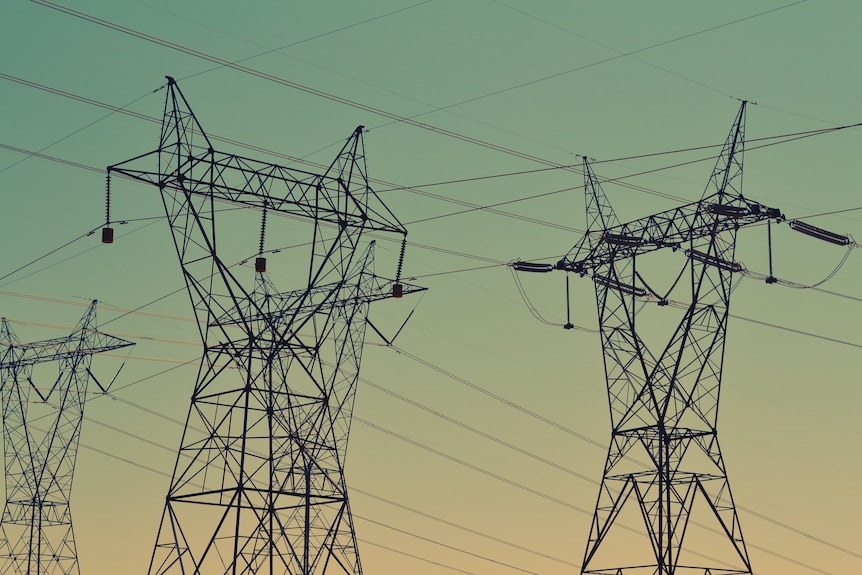 Black transmission towers under sunset sky