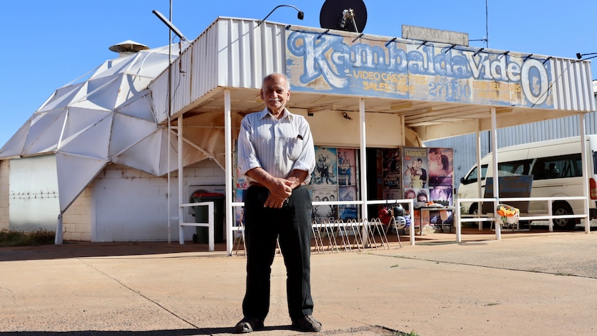 A man standing in front of his video shop, inside an ex drive-in kiosk