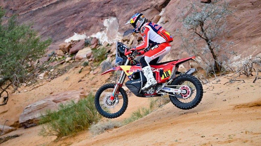 An Australian motorbike rider gets airborne as he rides through the desert during a big rally stage race.