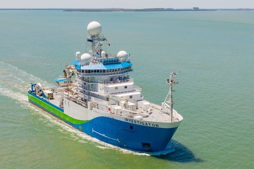 A large blue and white ship with radars on the bridge