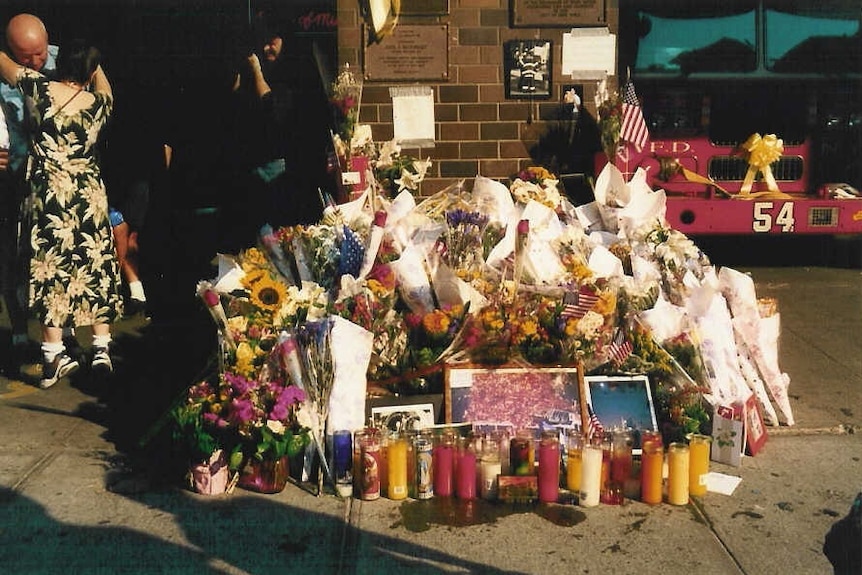 Locals embrace in New York next to a memorial for September 11 victims in the days after the terrorist attacks.