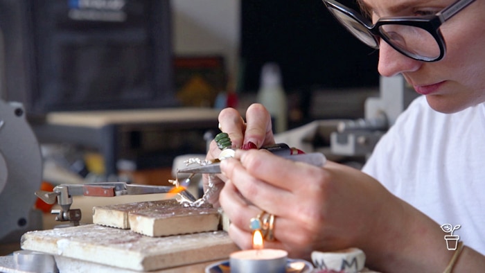 Woman wearing glasses making jewellery