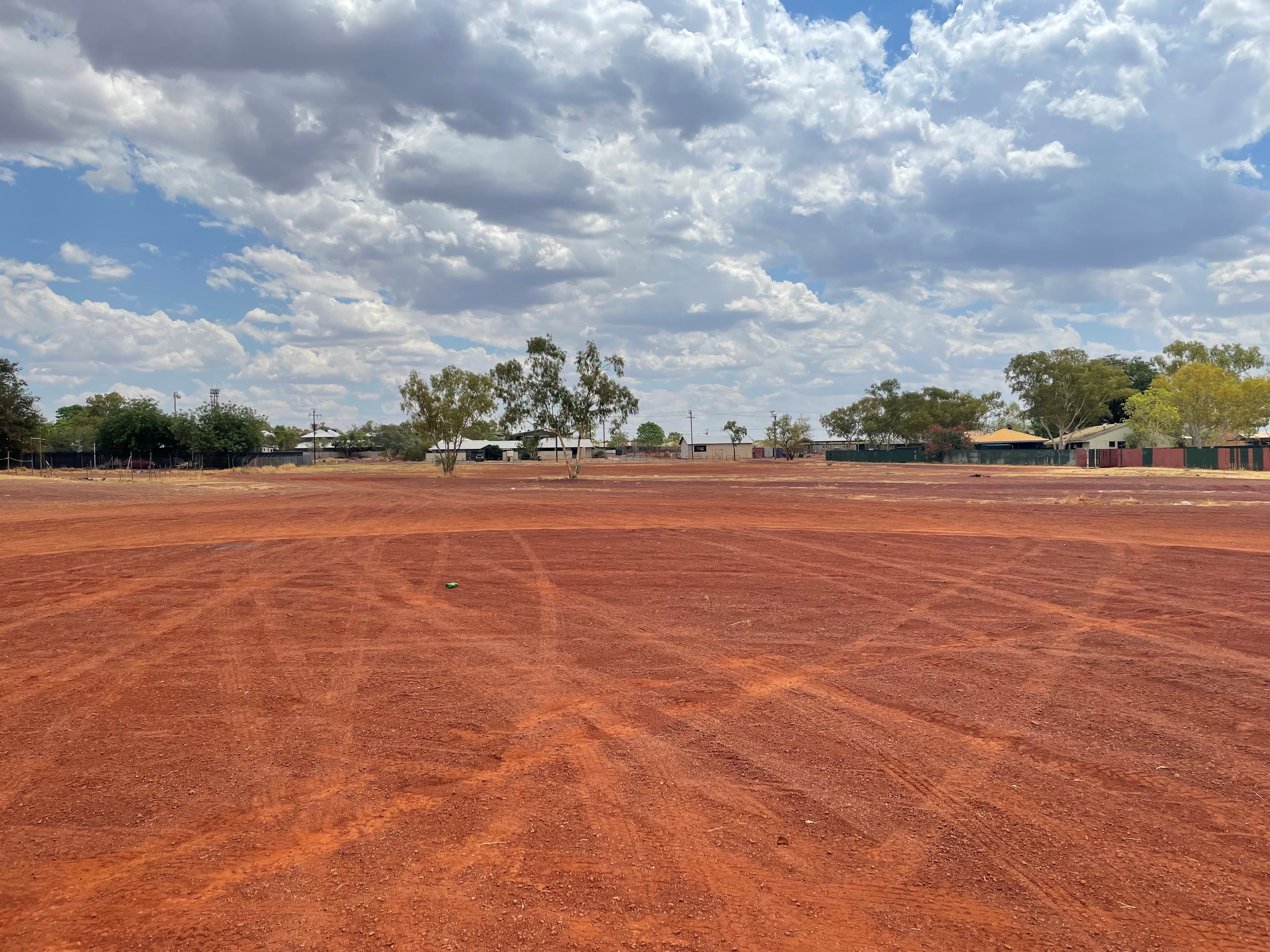 a large area of red gravel near houses