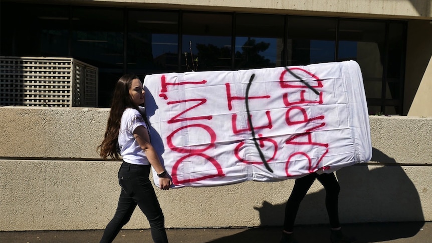 A student carries a mattress at Sydney University to protest sexual assault on campus, August, 2016.