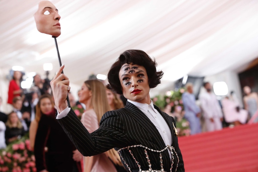 Ezra Miller had 5 extra eyes on his face, and carries a mask in one hand