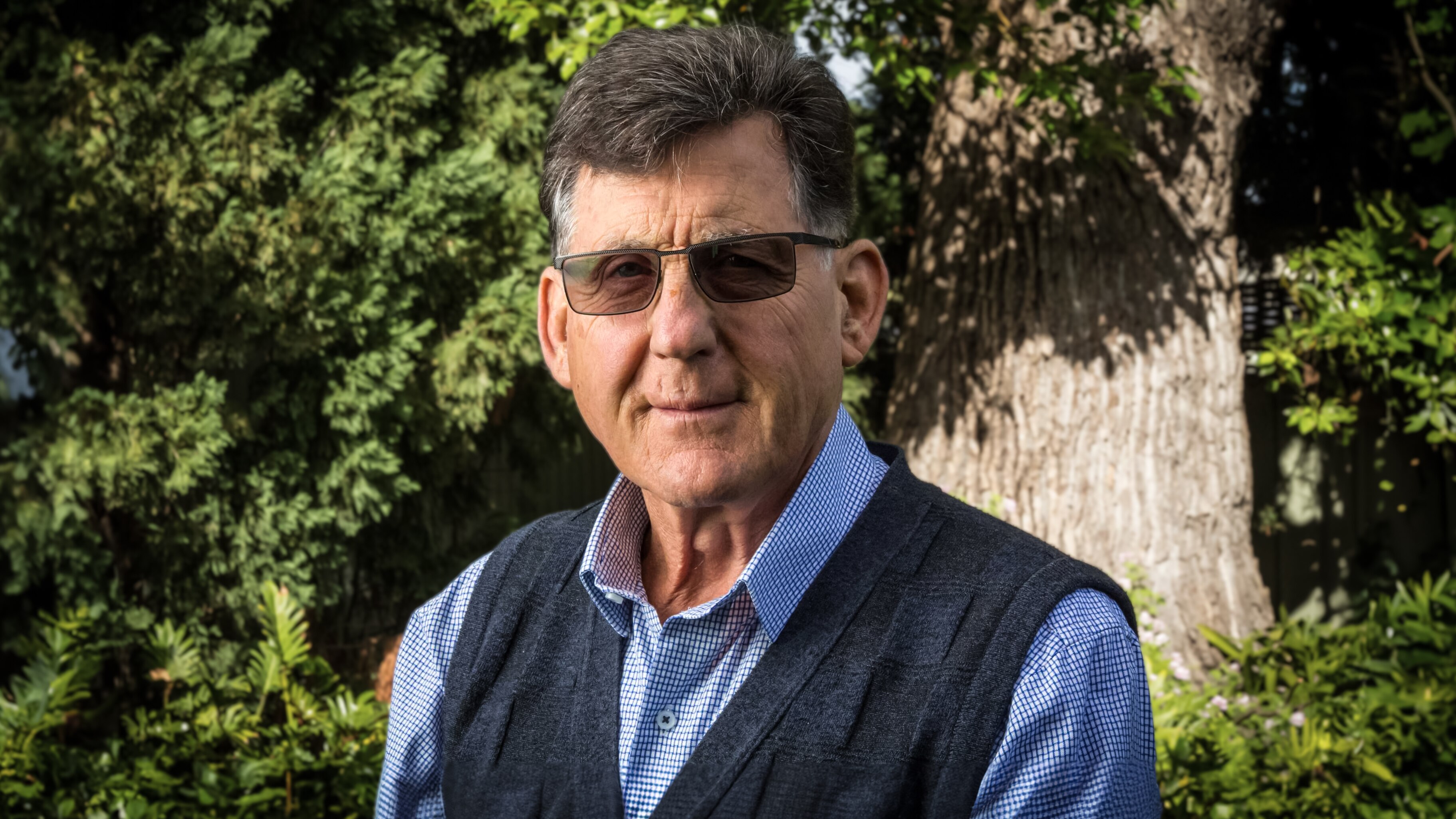 Dr John Ward stands in a garden.